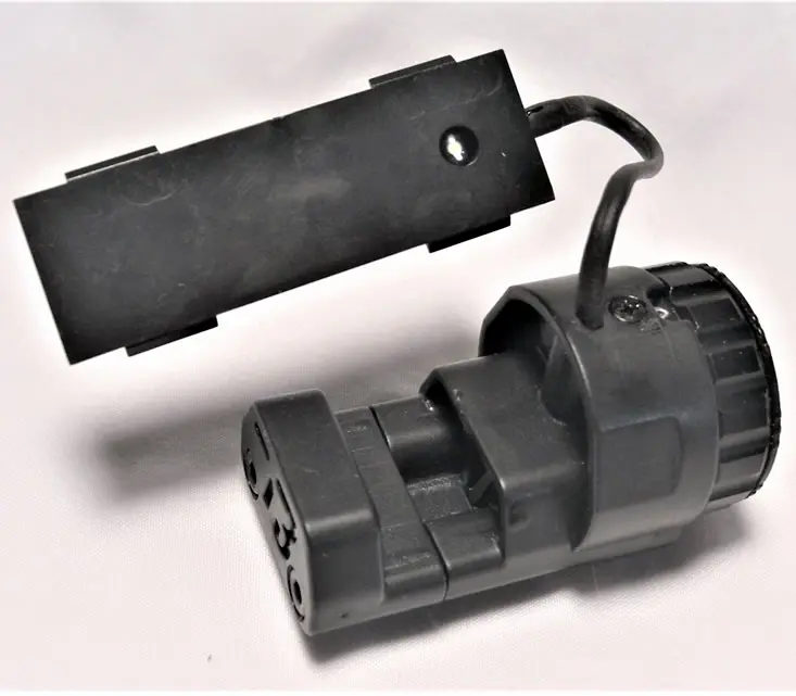 A black plastic connector with an electrical wire attached to it.